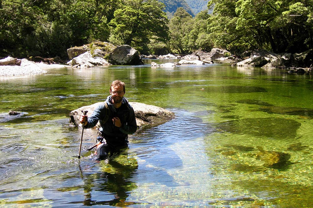A team member wading a clear river
